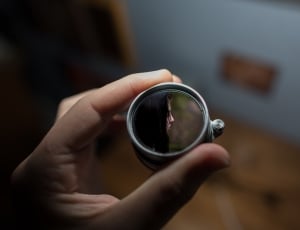 shallow focus photography of silver round device showing woman thumbnail