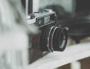 black and gray slr camera on white wooden fence thumbnail