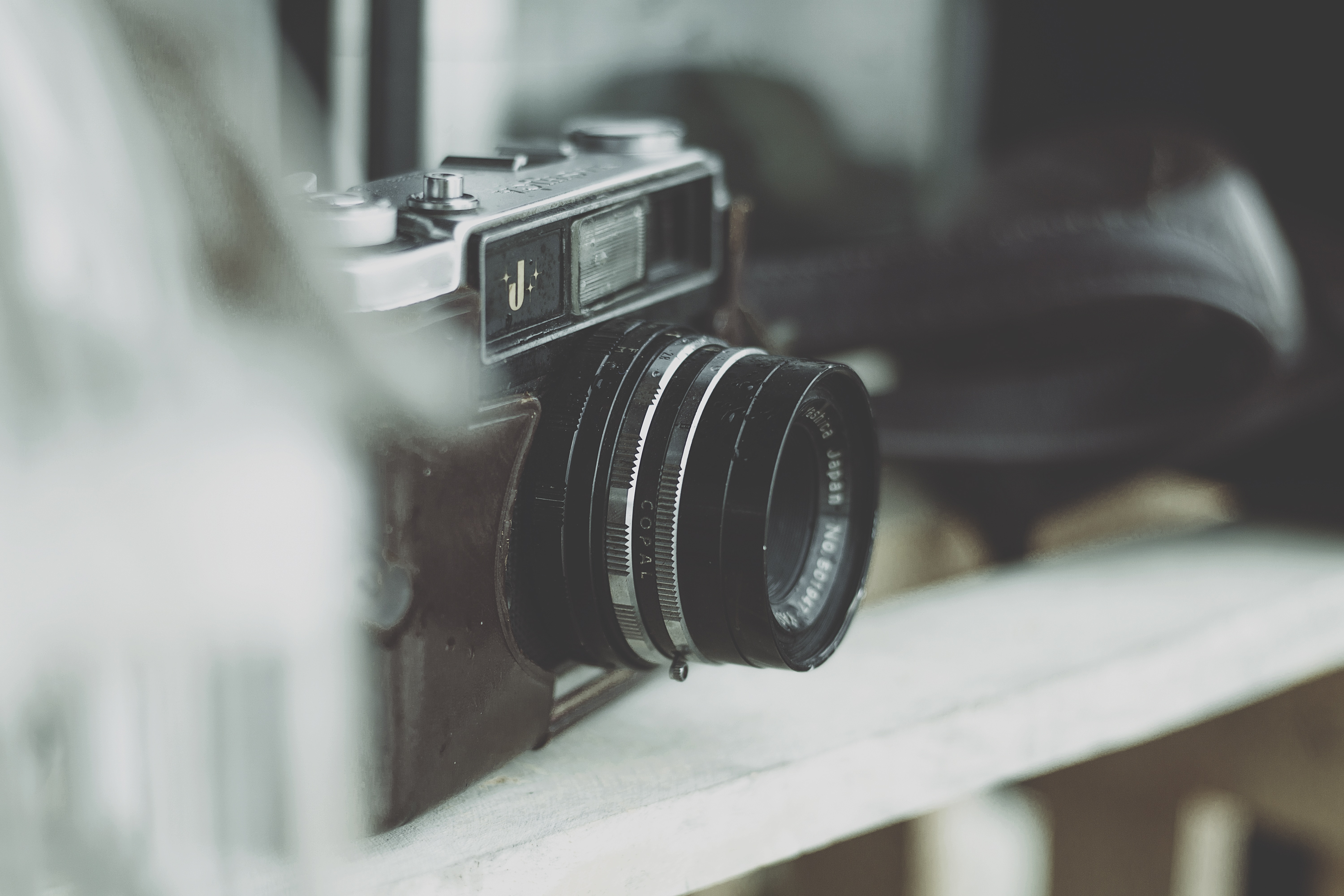 black and gray slr camera on white wooden fence