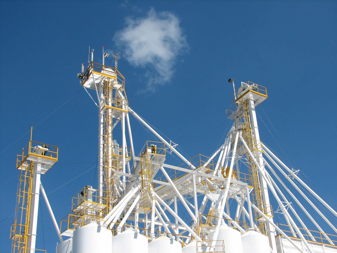 white and yellow industrial plant towers