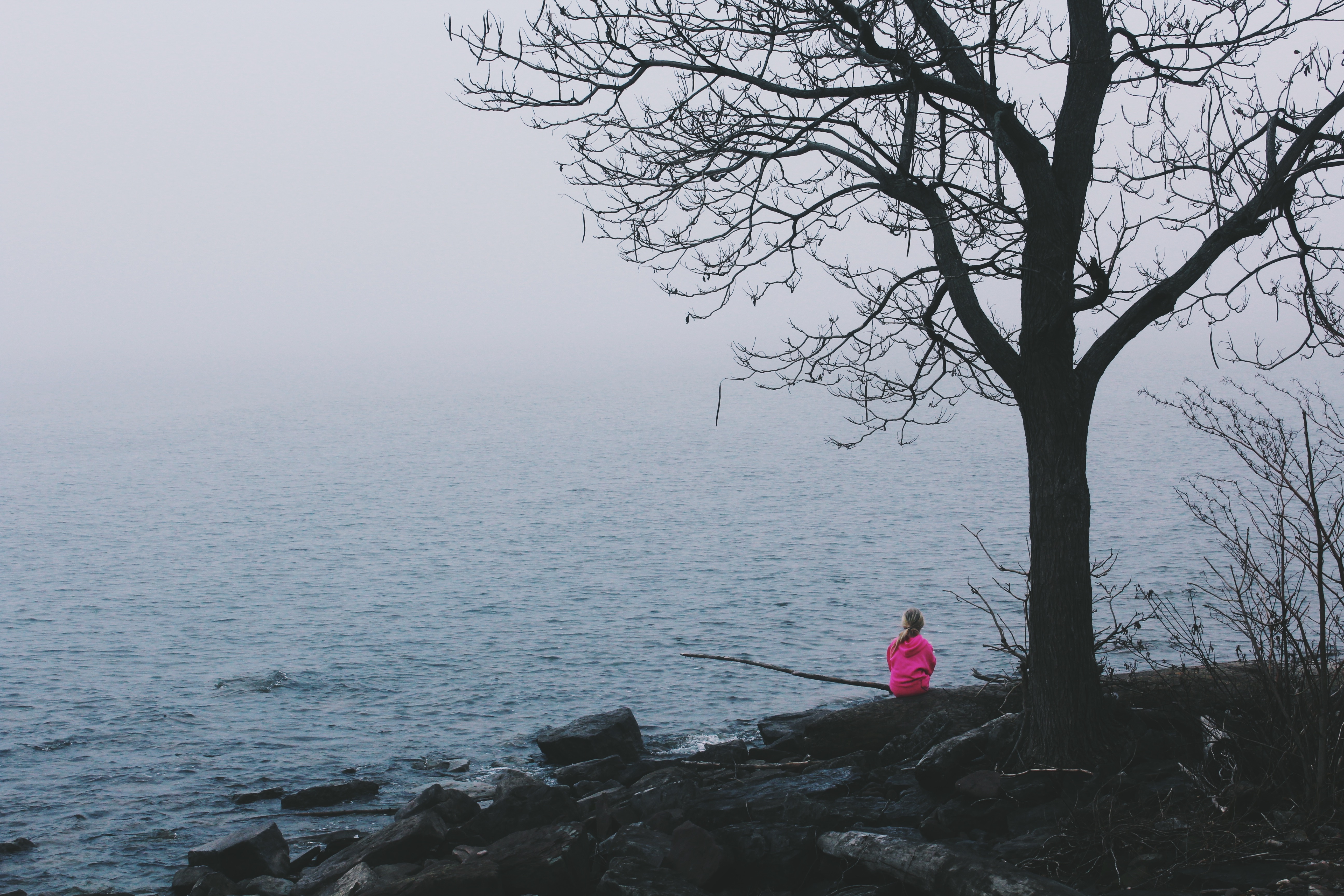 woman in pink jacket near body of water