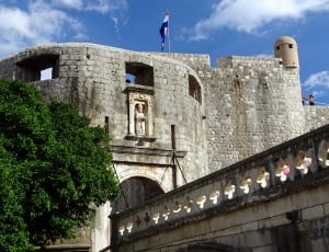 gray stone building with flag thumbnail