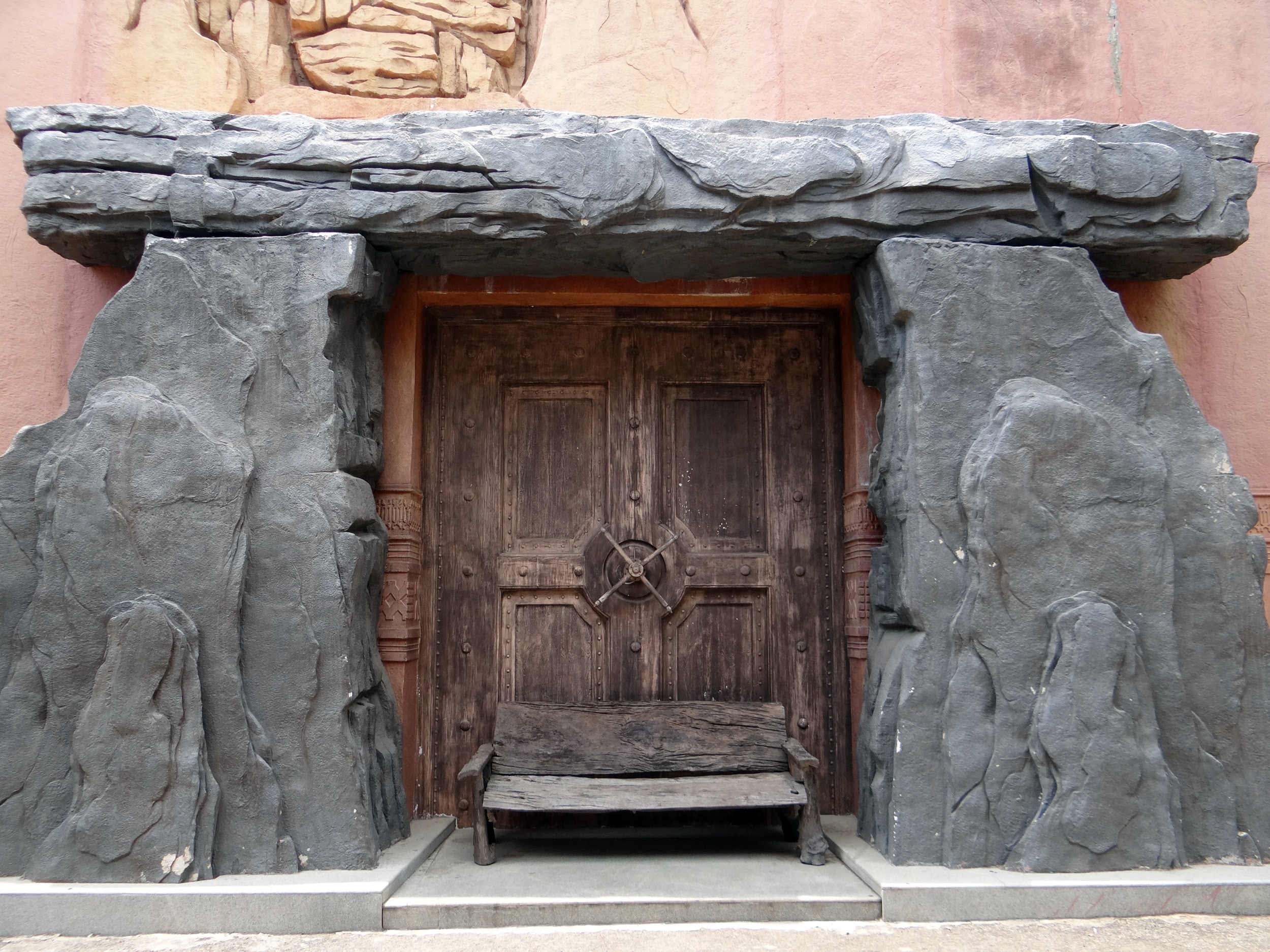 brown wooden door between concrete stone hendge