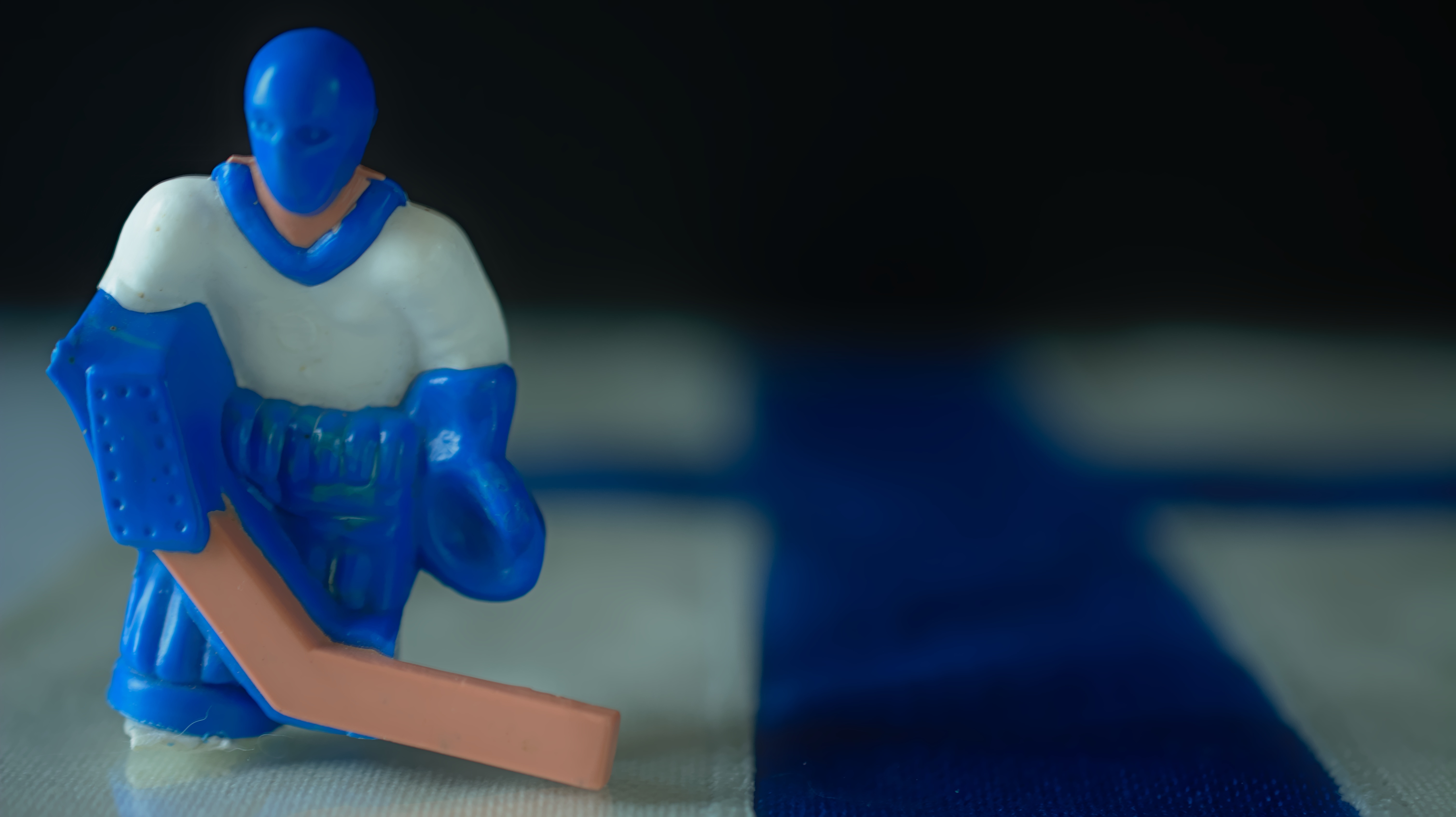 white and blue ice hockey player plastic figurine