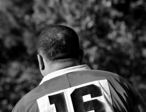 grayscale photo of man in number 16 jersey shirt facing backwards thumbnail