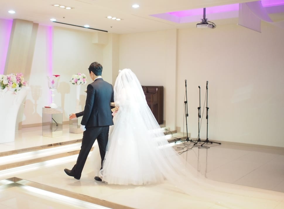 groom and bride walking towards the stage inside function hall preview