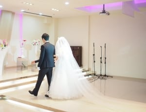 groom and bride walking towards the stage inside function hall thumbnail