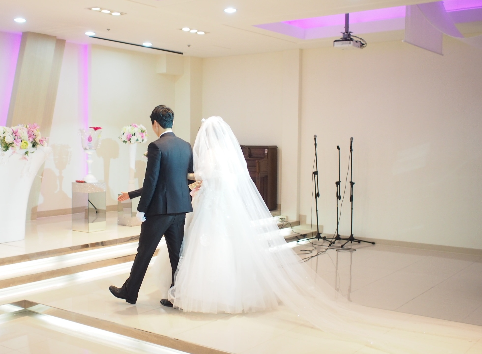 groom and bride walking towards the stage inside function hall