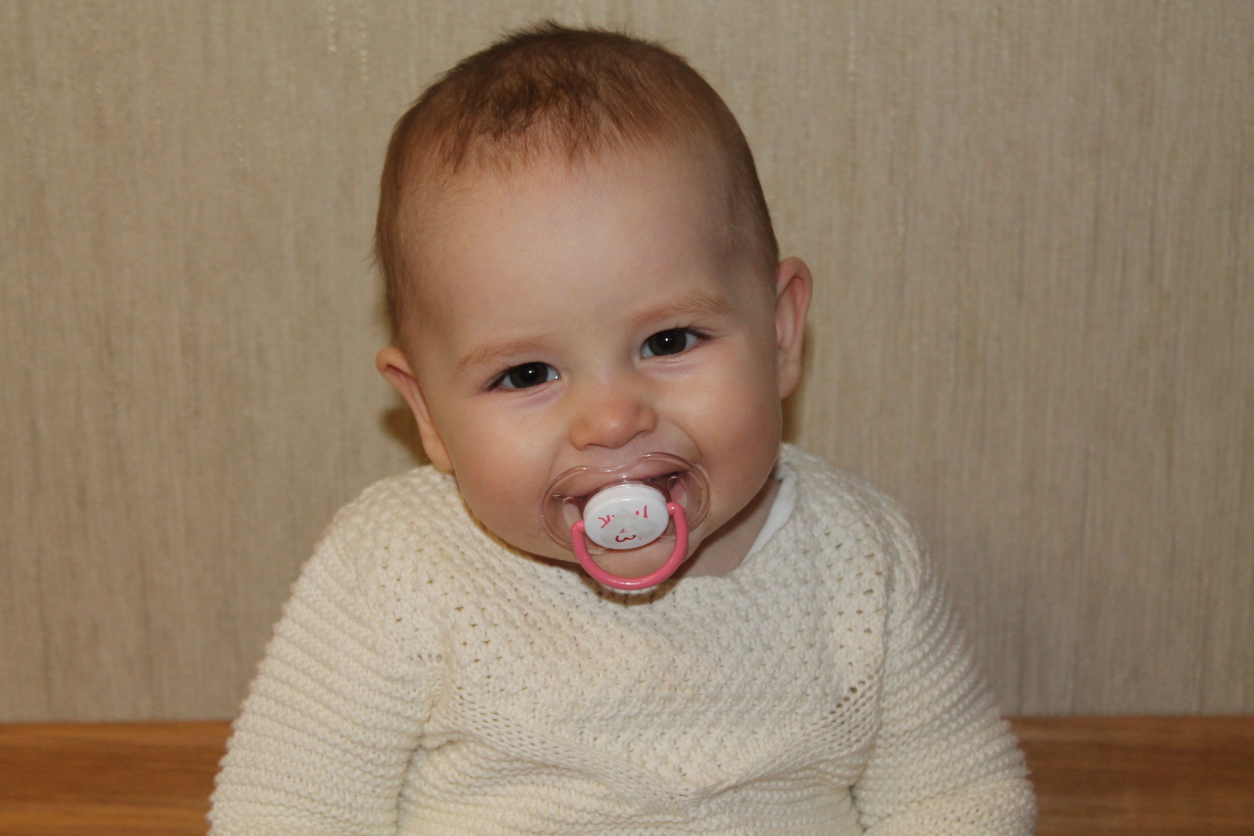 pacifier and baby's white sweater