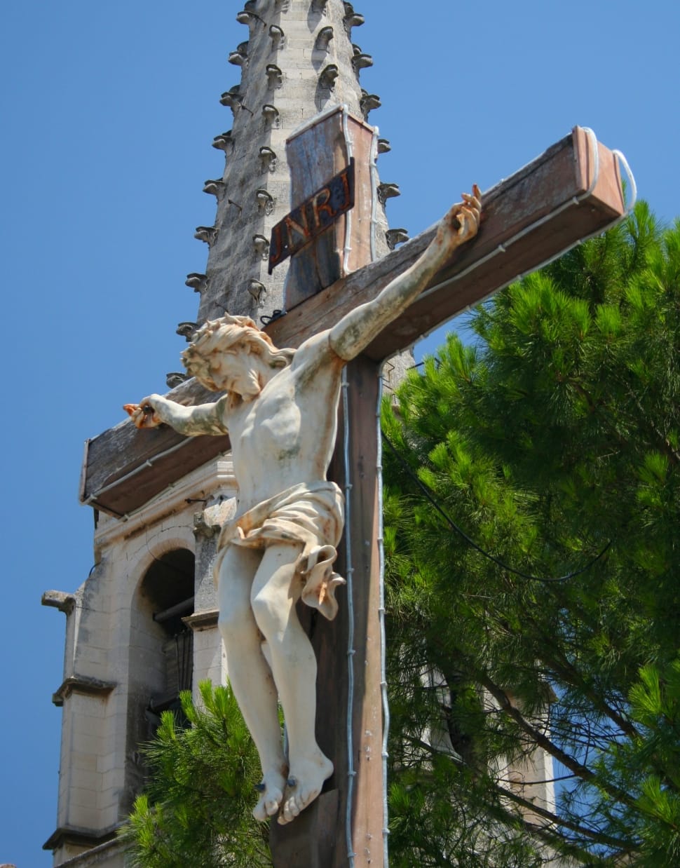 crucifix art near green leaf tree preview