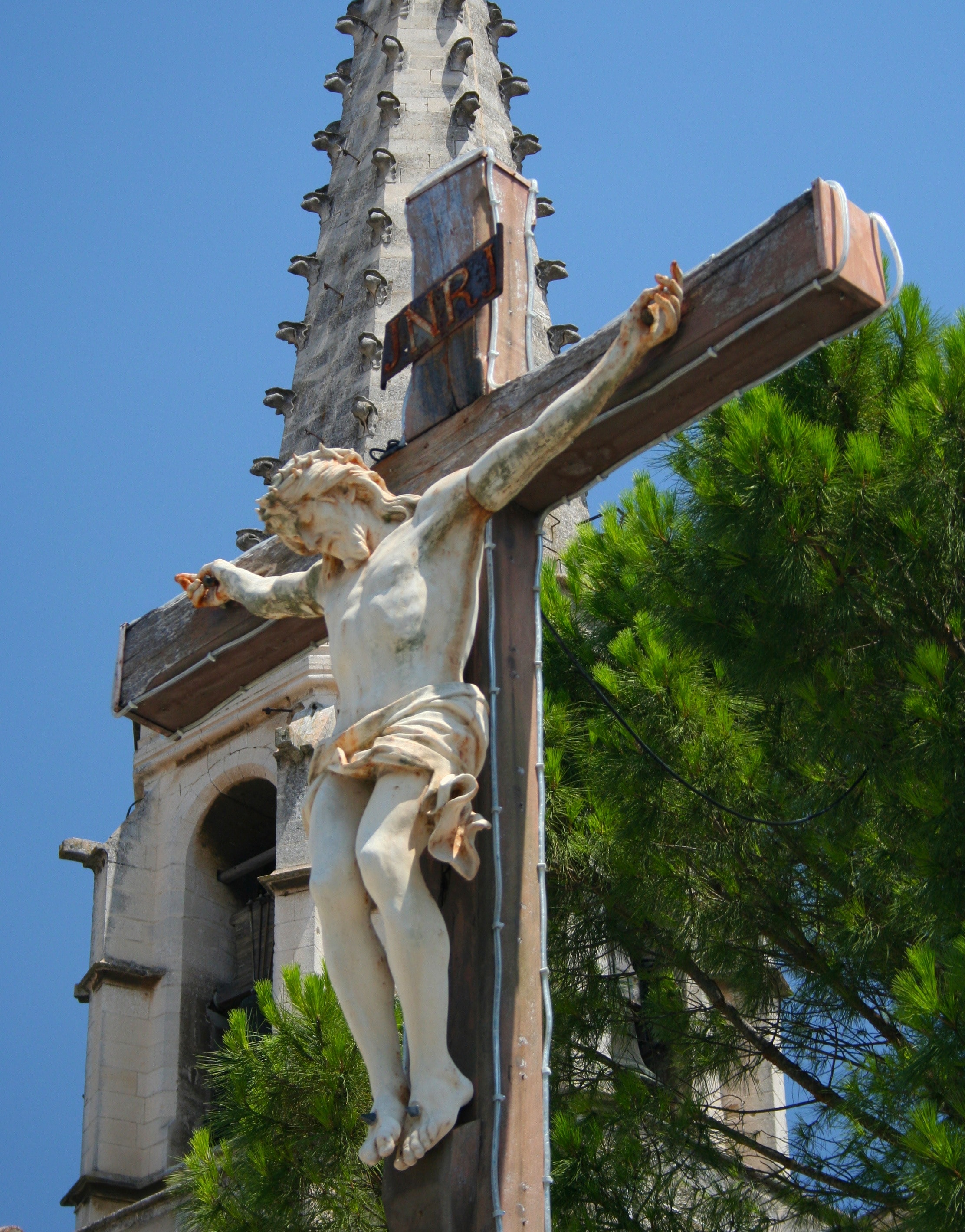 crucifix art near green leaf tree