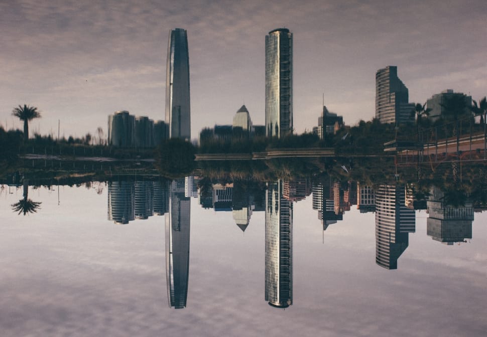 three high rise buildings reflecting on water preview