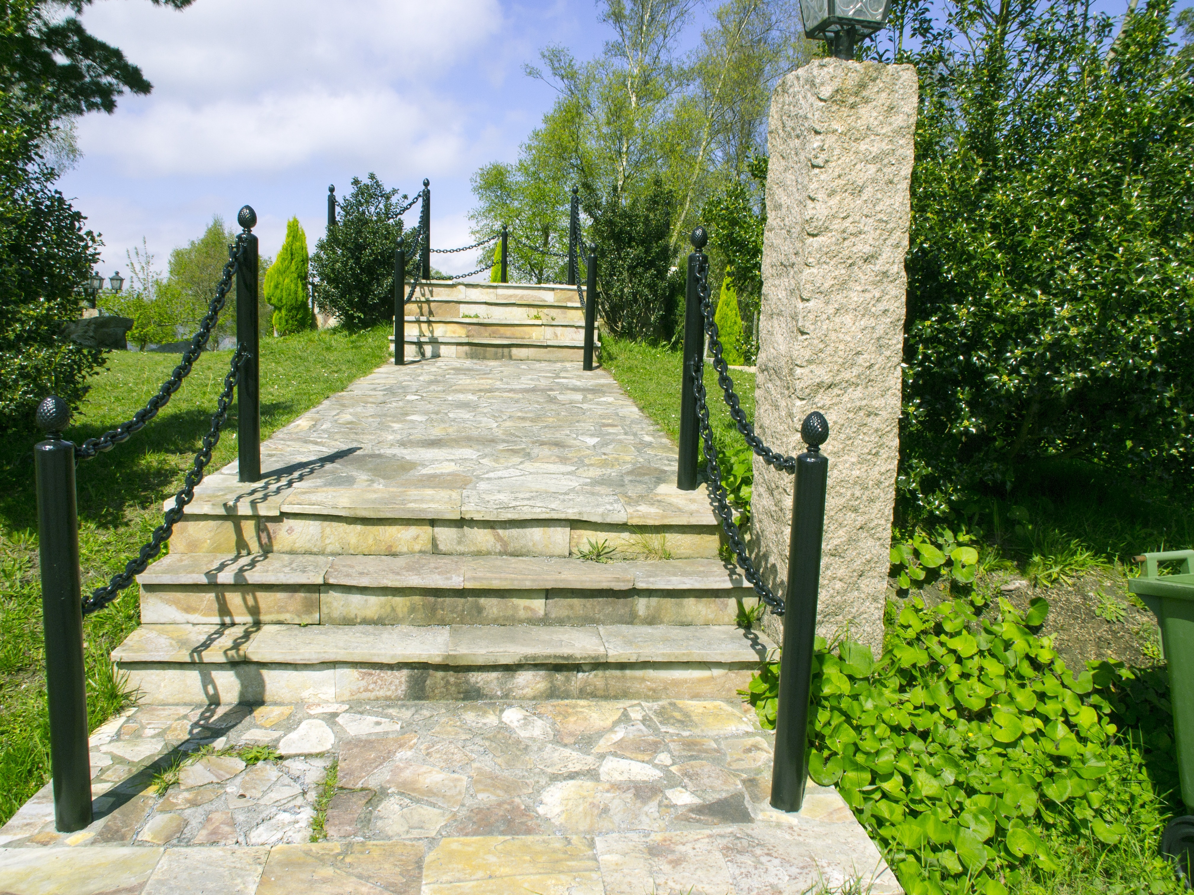 grey stairs with tiles and railings near tall trees during daytime