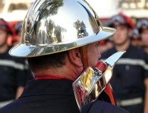 firefighter wearing gold-colored fire axe and helmet thumbnail