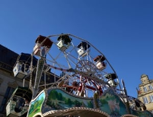 low angle view of ferris wheel under blue skies thumbnail