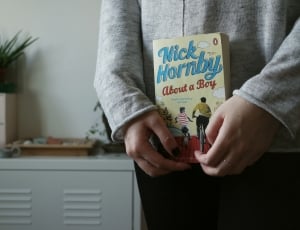 person in gray long sleeve shirt holding nich hornby about a boy bok thumbnail