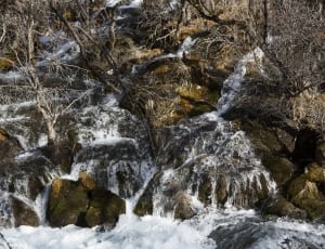 shallow focus photography of running water on mountain during daytime thumbnail