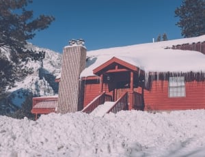 red painted wooden shed with snow thumbnail