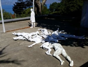 human's white statue lot near the road thumbnail