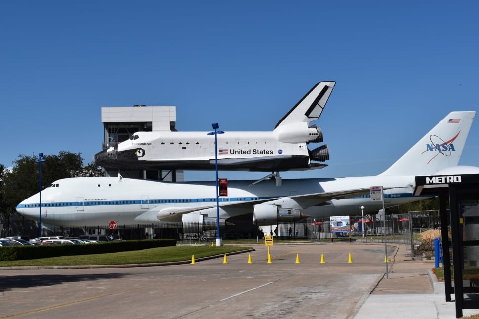white nasa passenger plane with white and black united states space shuttle during day time preview