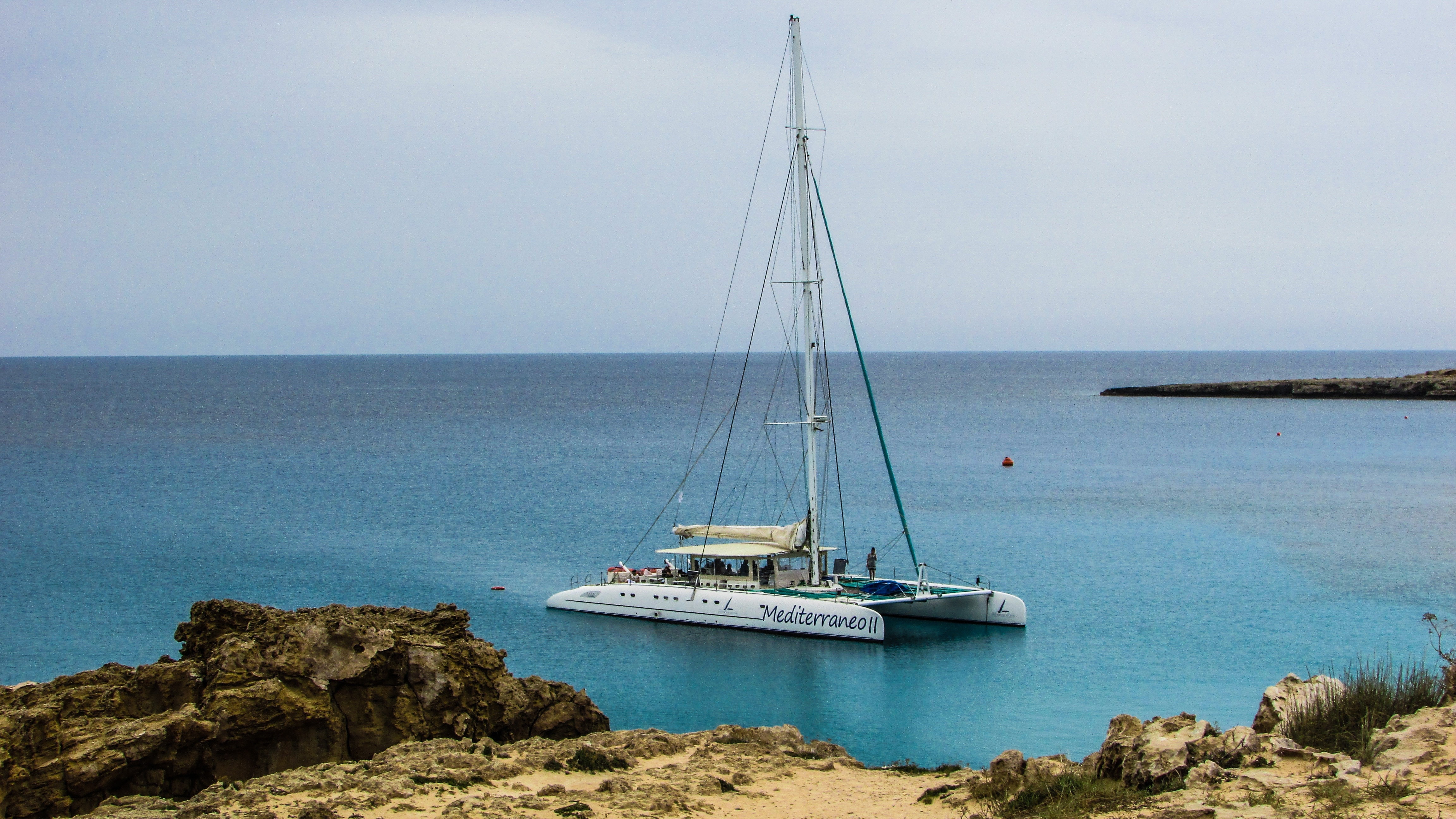 white sail boat on ocean shore during daytime