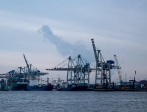 grey tower crane near sea during dayttime thumbnail