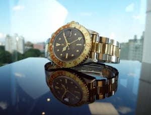 two tone gold and link black analog watch thumbnail
