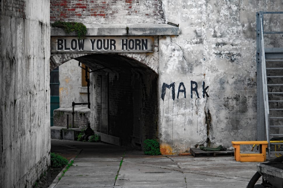 gray concrete wall with blow your horn signboard preview