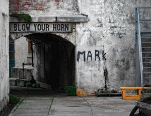 gray concrete wall with blow your horn signboard thumbnail