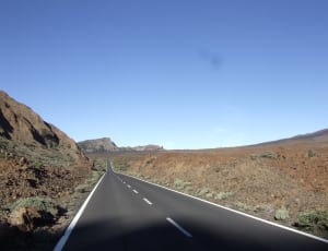 grey asphalt road near mountain during daytime thumbnail