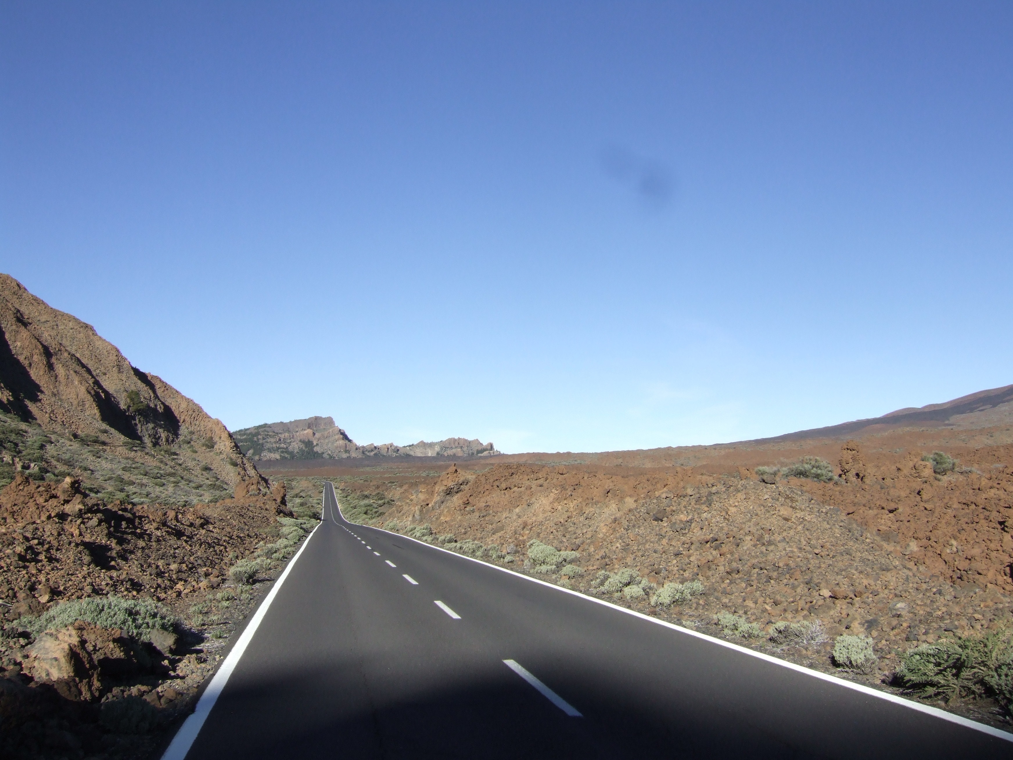 grey asphalt road near mountain during daytime