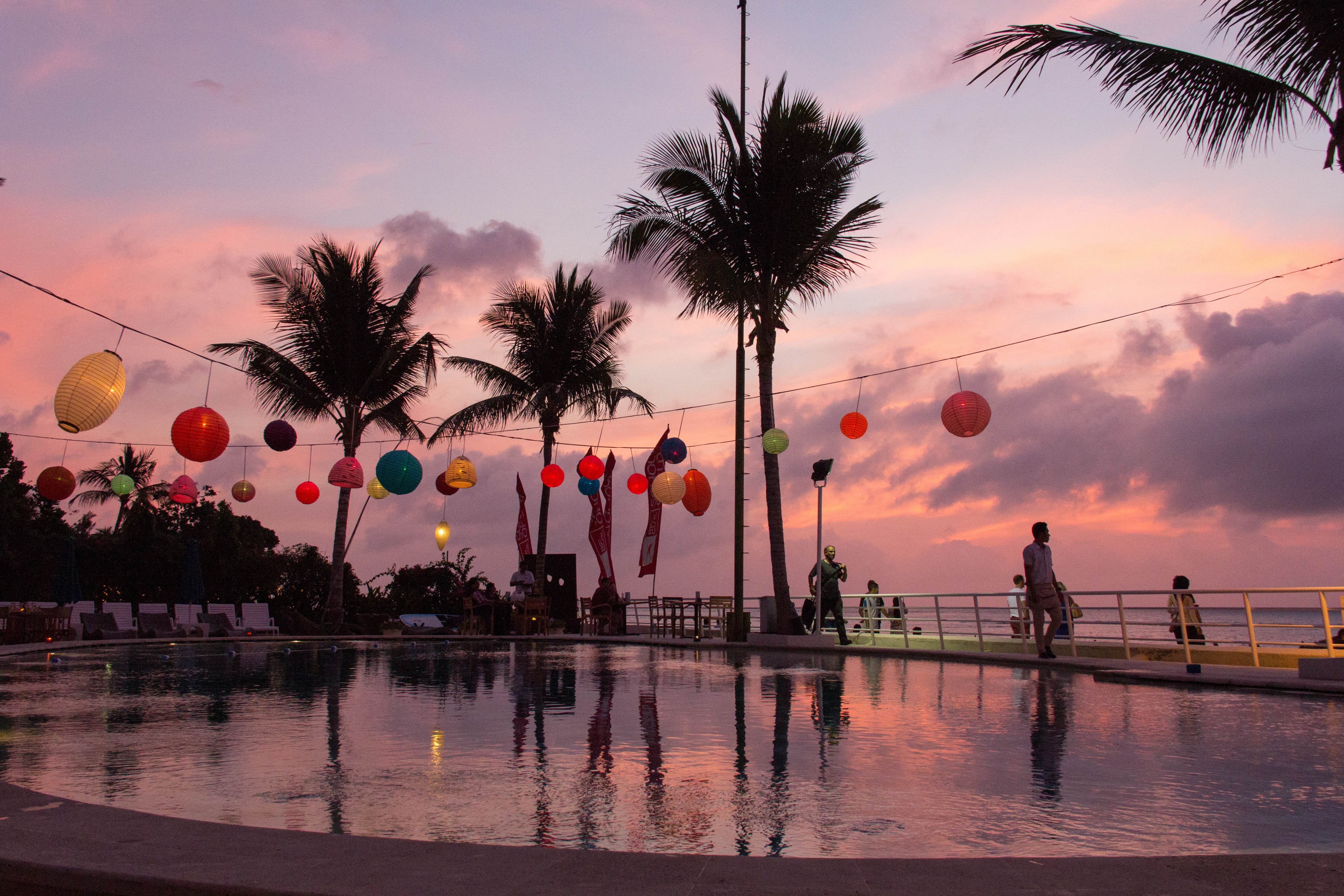 swimming pool with hanging lanterns during sunset