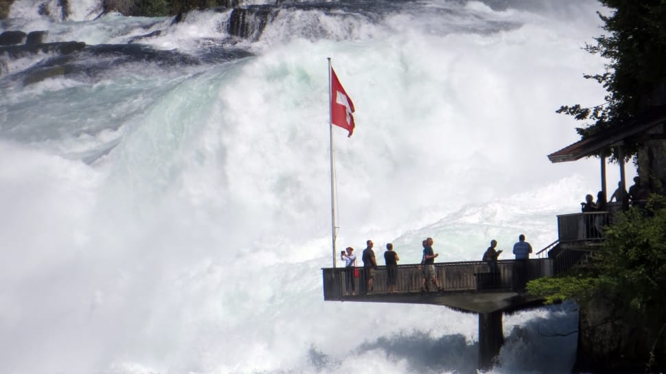 white and red cross flag next to waterfalls preview