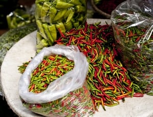 assorted green and red chilis on plate thumbnail