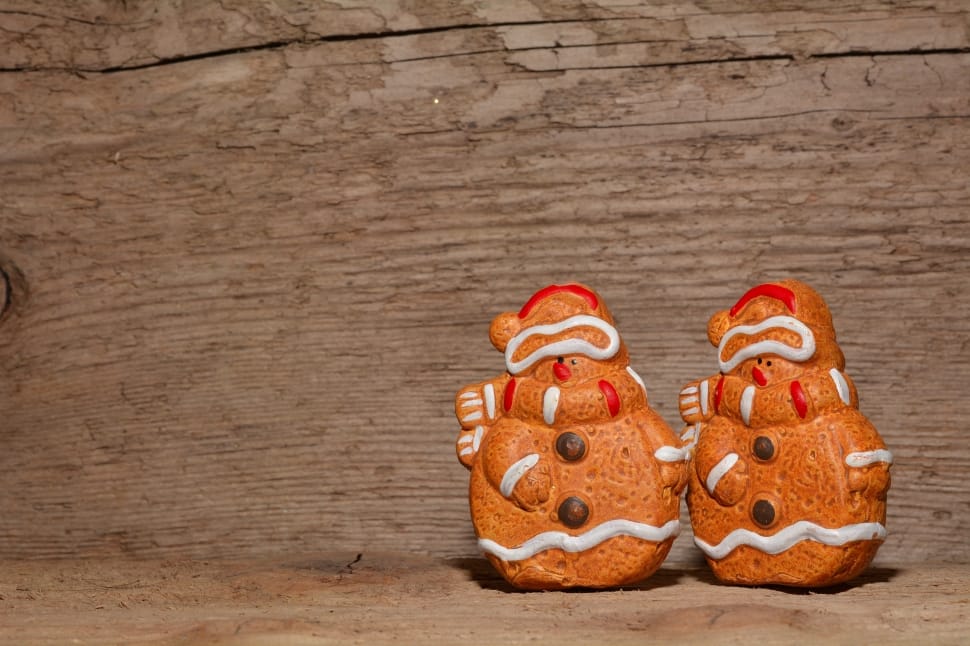 two orange snowman gingerbread decors on brown wooden desk preview