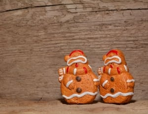 two orange snowman gingerbread decors on brown wooden desk thumbnail