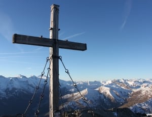 gray wooden cross near glacier mountains at daytime thumbnail