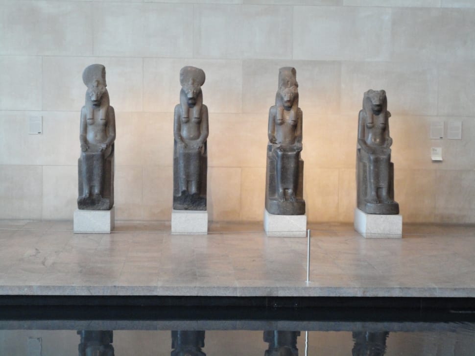 four egyptian figurines on top of gray granite table preview