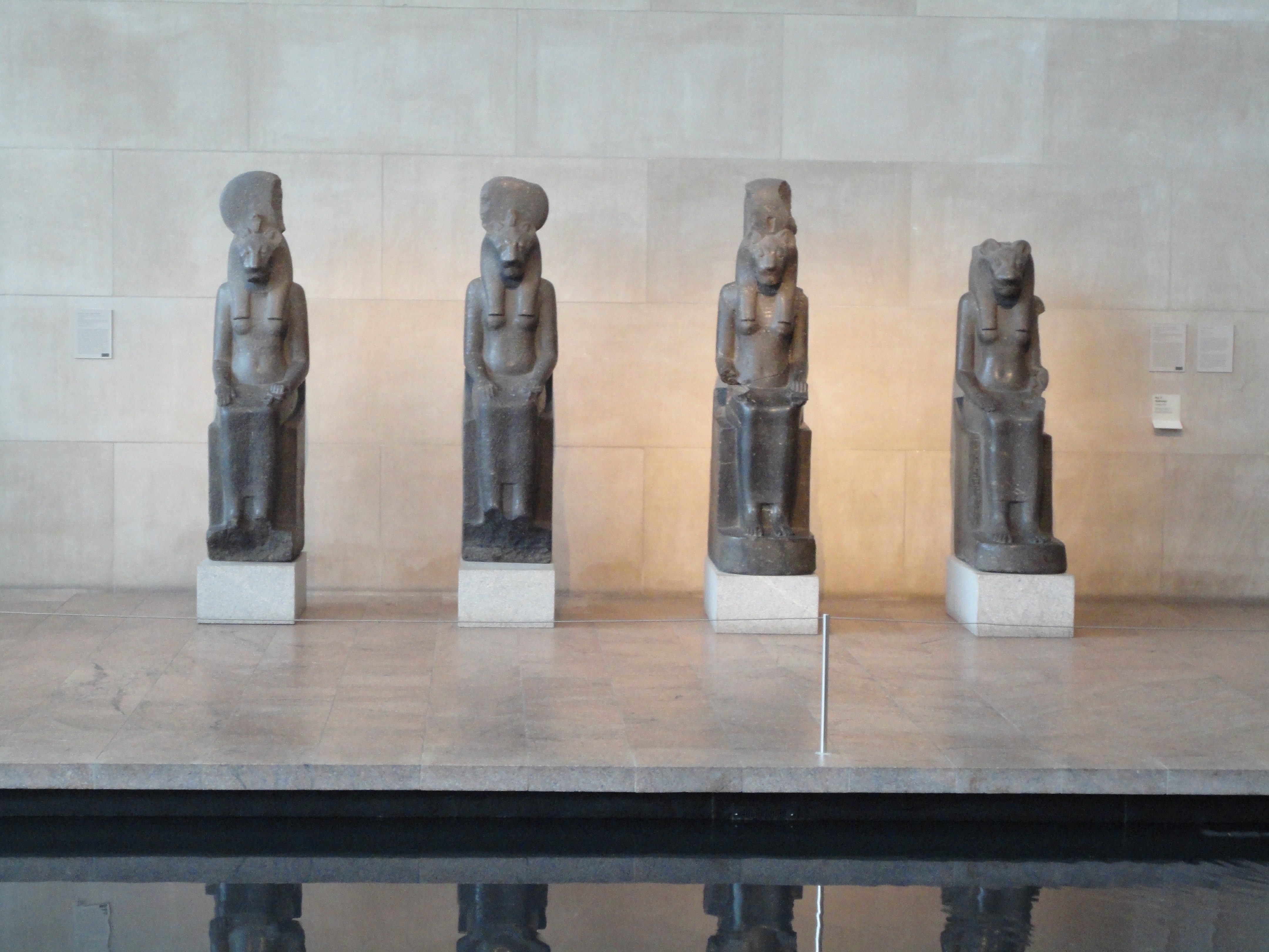 four egyptian figurines on top of gray granite table