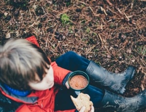 boy in red coat holding container and bread thumbnail