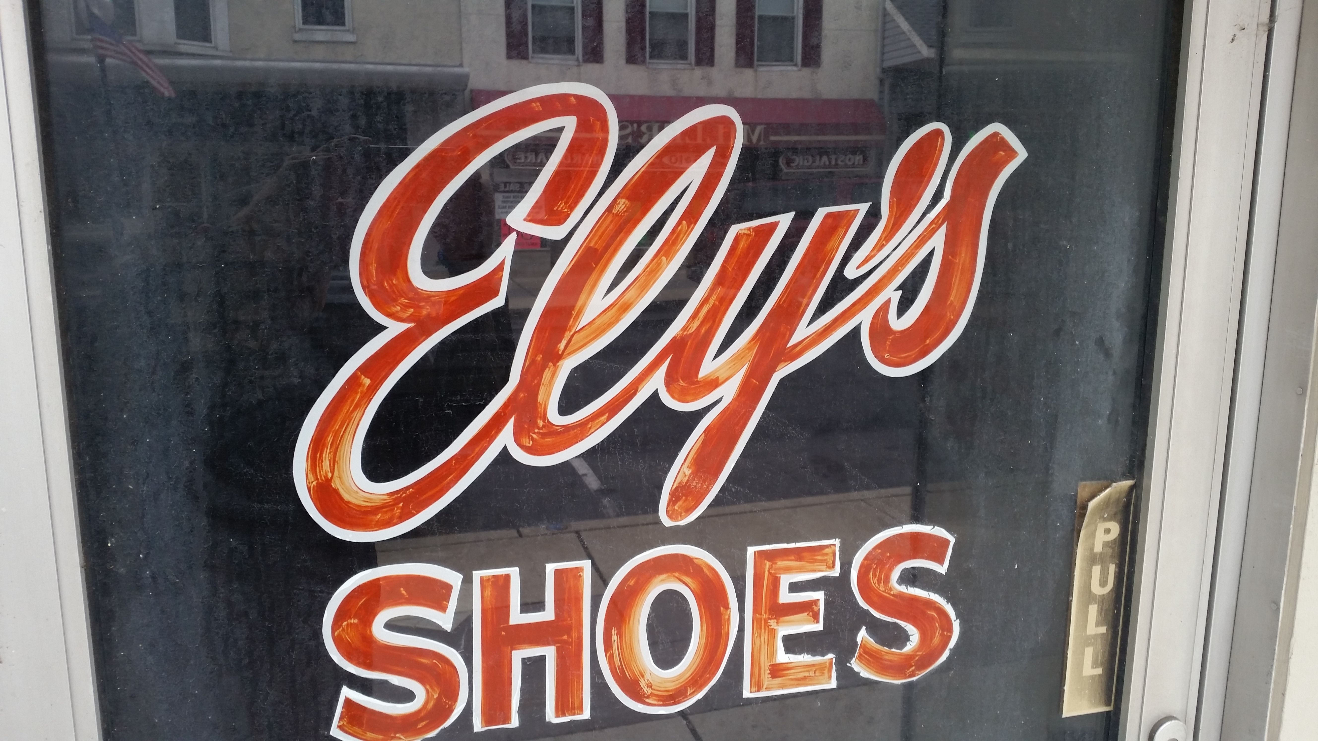 white wooden framed ely's shoes signage