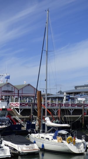 white yacht docked near green and white pier thumbnail