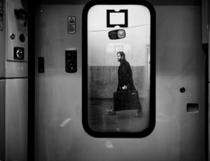 greyscale photography of person walking on the train station thumbnail