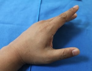 close-up photo of a person's hand on blue textile thumbnail