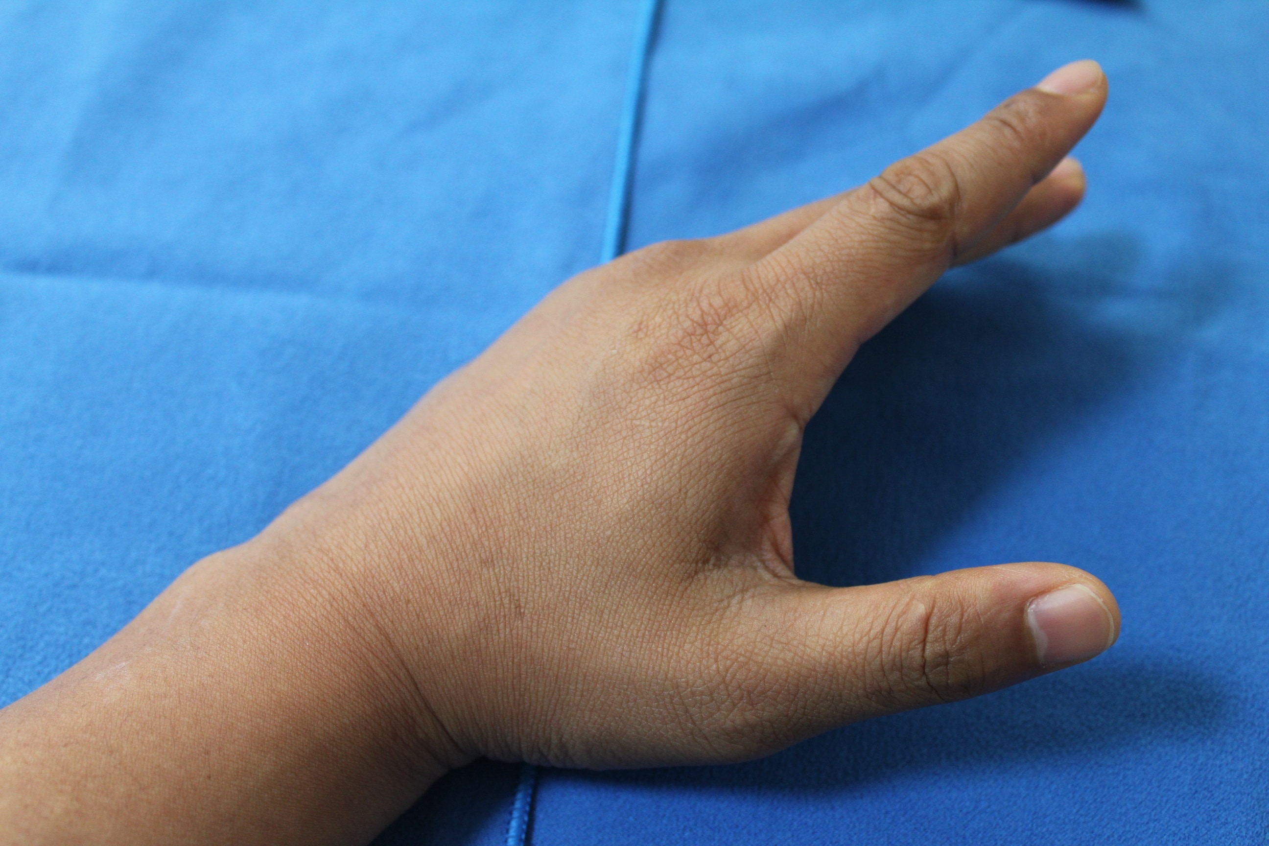 close-up photo of a person's hand on blue textile