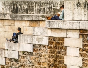 woman and man sitting on concrete stairs thumbnail
