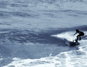 black wet suit and white surfboard thumbnail