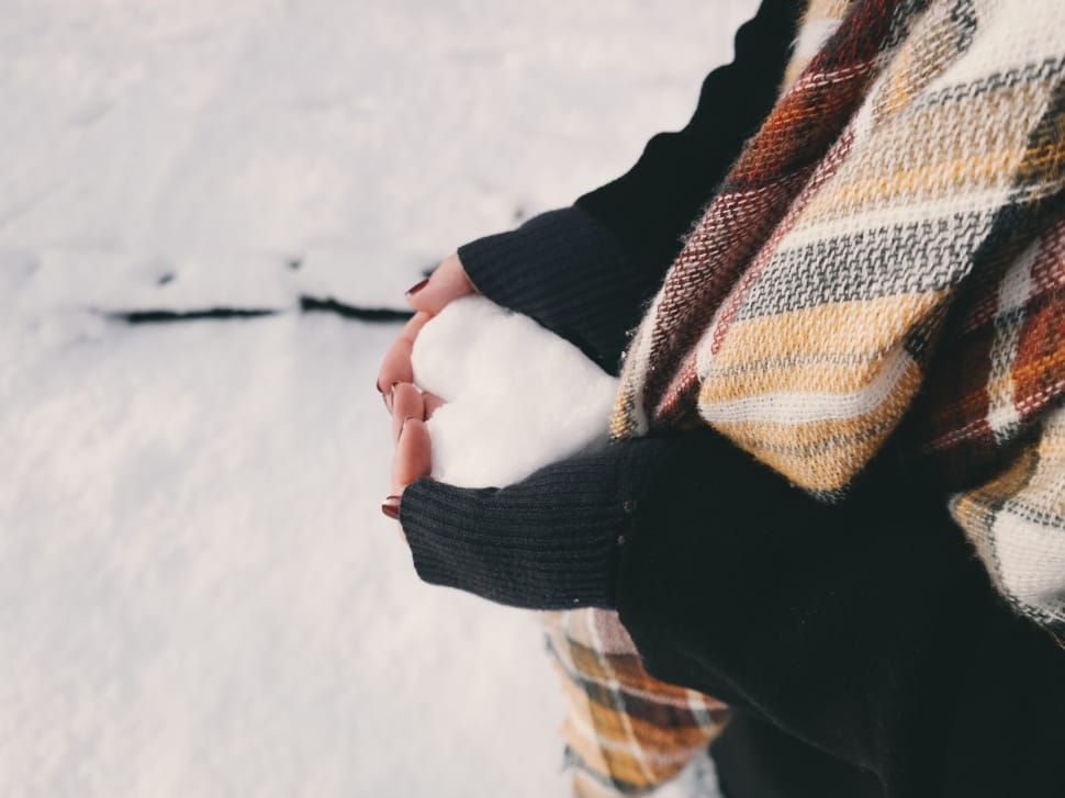 woman in sweater holding snow preview