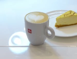 white and yellow sliced cake on white ceramic plate with white ceramic coffee mug thumbnail