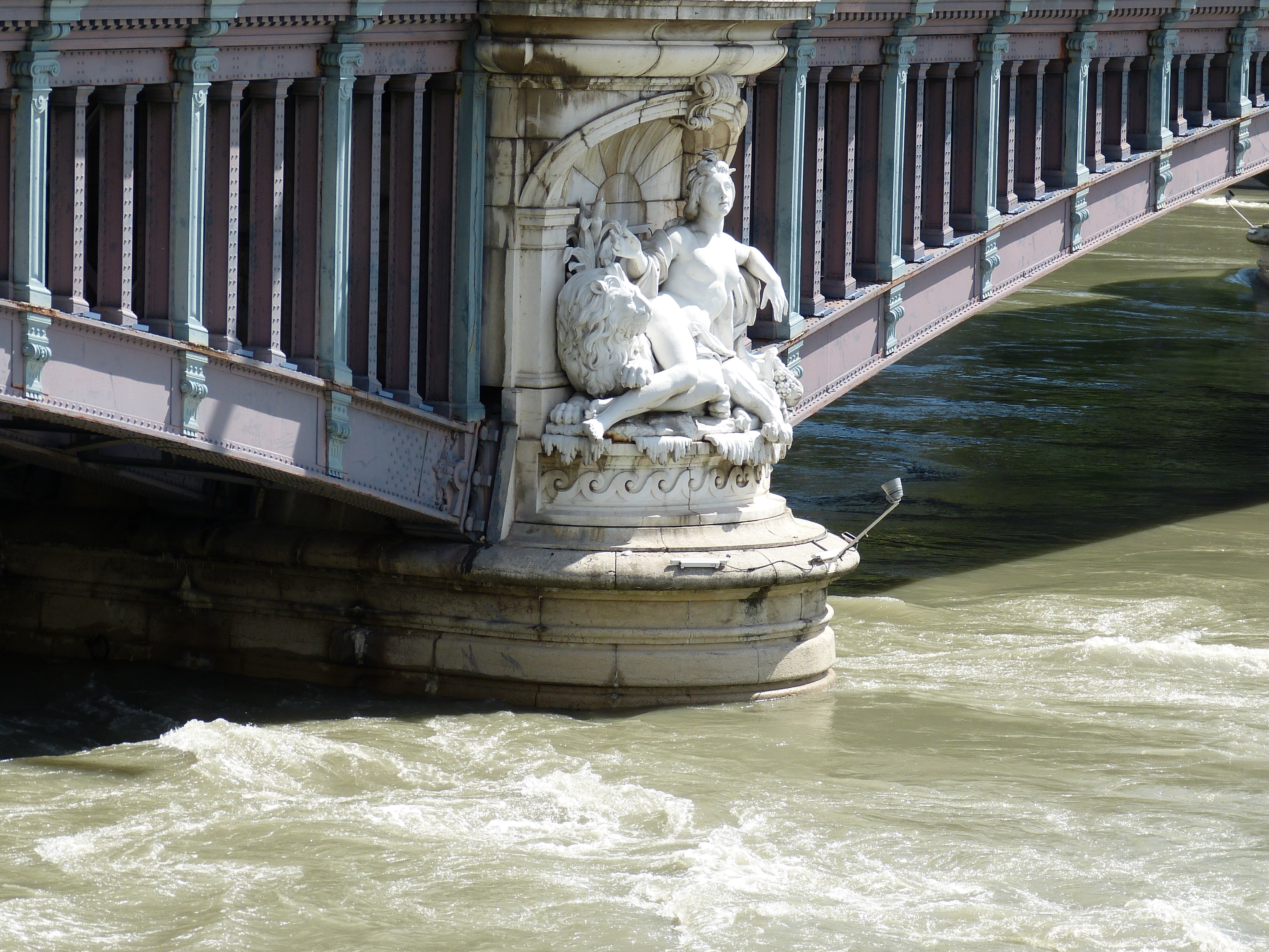 woman and lion statue under bridge